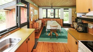 Een kleine keuken met houten kastjes, een eettafel en een koffieapparaat.
