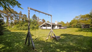 A wooden swing set in a grassy yard with a house in the background. - Nice home in Samsø with kitchen (Samsø)