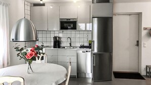 A modern kitchen with white cabinets, a stainless steel refrigerator, a built-in oven, and a coffee maker. - Stunning home in Sölvesborg with WiFi (Sölvesborg)