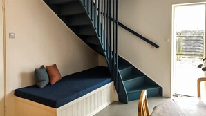 A room with a built-in bench along the wall, a staircase with black railings, and a door leading outside. - Stunning home in Sölvesborg with WiFi (Sölvesborg)