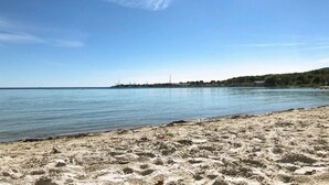 A sandy beach with calm water, a clear sky, and a distant shoreline with buildings. - Stunning home in Sölvesborg with WiFi (Sölvesborg)