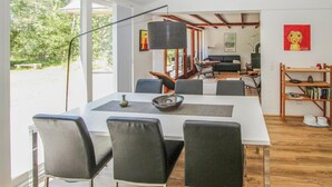 A modern dining area with a white table, black chairs, and a large floor lamp. - Beautiful home in Samsø with WiFi (Samsø)