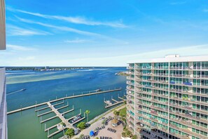 A high-rise hotel with a marina view, featuring balconies, a pool, and a dock.