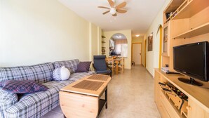 A furnished living room with a sofa, a coffee table, a TV, and a wooden cabinet with drawers. - 2 bedroom awesome apartment in Oropesa del Mar (Oropesa del Mar)