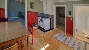 A kitchen with a built-in stove, wooden flooring, and a red chair. - 1 bedroom stunning home in Auktsjaur (Auktsjaur)