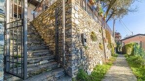 Un bâtiment en pierre avec un portail en métal et des marches menant à une porte.