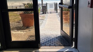 A doorway leading to a beach with a sign prohibiting pets. - Friends & Family Beach Escape - Double Oceanview Studio Sleeps up to 10 (Daytona Beach)