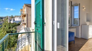 A balcony with a green door, a glass door, and a view of neighboring buildings. - 1 bedroom stunning apartment in Varazze (Varazze)