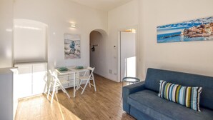 A compact living space with a dining area, a sofa, and a painting of a coastal scene. - 1 bedroom stunning apartment in Varazze (Varazze)