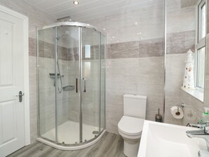 A modern bathroom with a glass-enclosed shower, a white toilet, and a sink with a mirror. - Creel Cottage, Blackwood Street (Morpeth)
