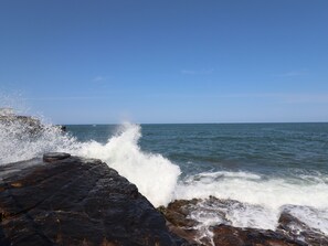 A rocky shoreline with waves crashing against it. - Creel Cottage, Blackwood Street (Morpeth)