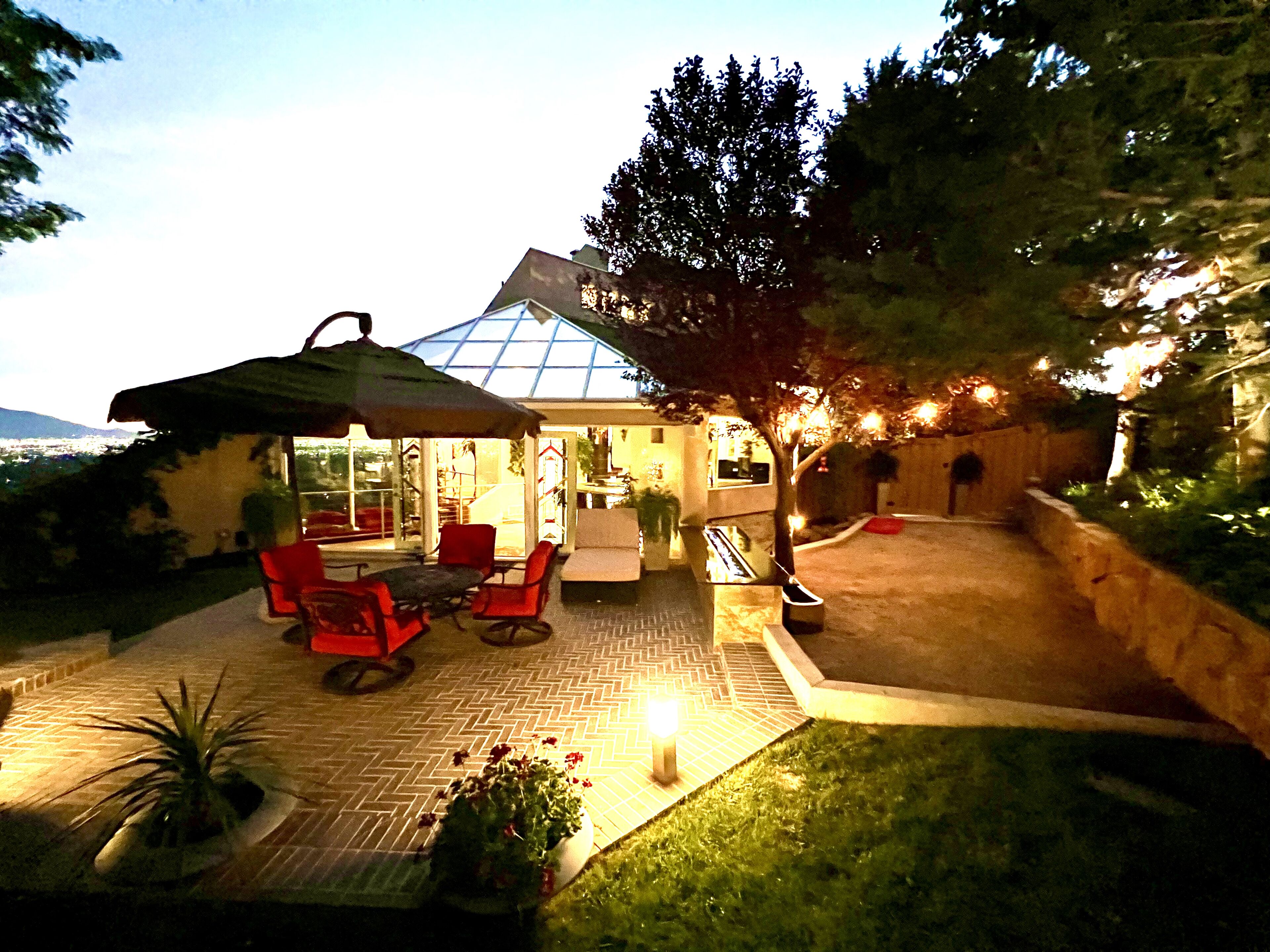 Eine Terrasse mit Gartenmöbeln und einer Glaseinfassung.