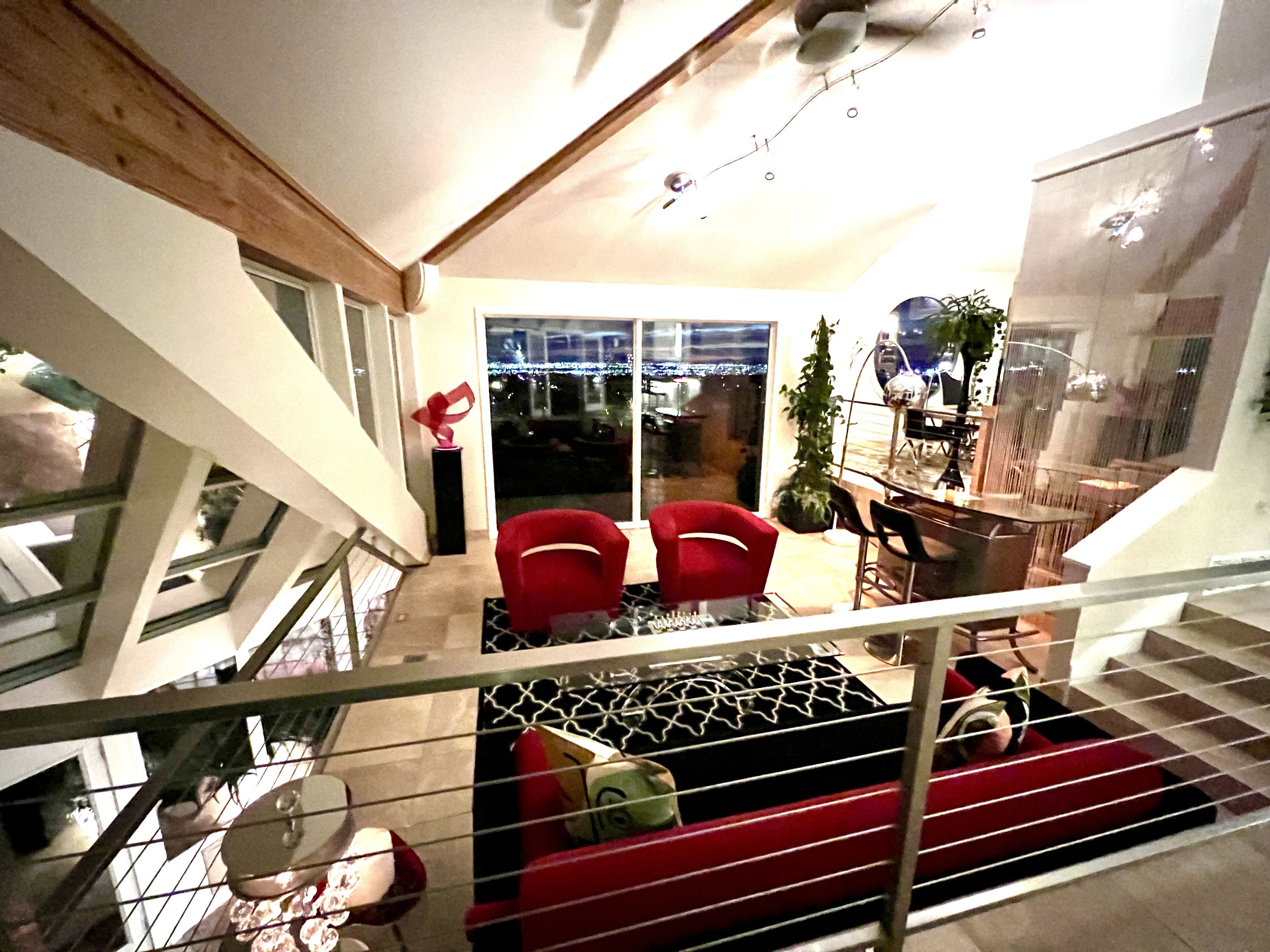 Ein modernes Interieur mit Treppe, roten Stühlen und einem Essbereich.
