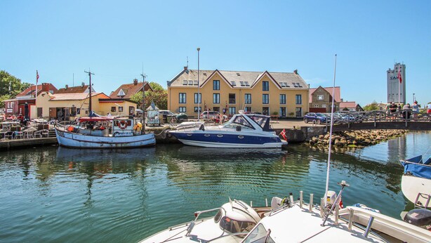 A marina with boats docked, a building with multiple windows, and a clear sky. - Lovely apartment in Samsø (Samsø)