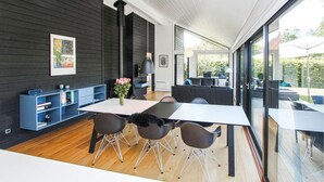 A modern dining area with a white table, four chairs, and a vase of flowers. - Awesome home in Samsø with WiFi (Samsø)