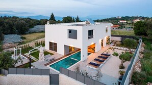 A modern two-story house with a swimming pool, outdoor seating, and a view of the surrounding landscape. - Pet friendly home in Skrip (Skrip)