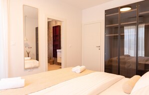 A hotel room with a large bed, a wardrobe with a mirror, a bathroom with a red cabinet, and a view through a glass door. - Pet friendly home in Skrip (Skrip)