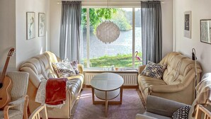 A living room with two sofas, a coffee table, and a guitar. - Nice home in Tjörnarp (Tjörnarp)