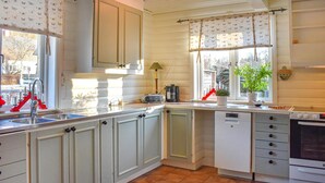 A kitchen with white cabinets, a sink, a stove, and a window with curtains. - Stunning home in Svängsta with sauna (Svängsta)