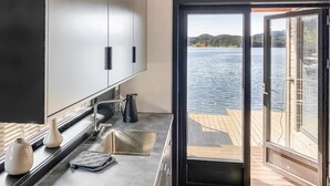 A kitchen with a view of a lake through a sliding door.