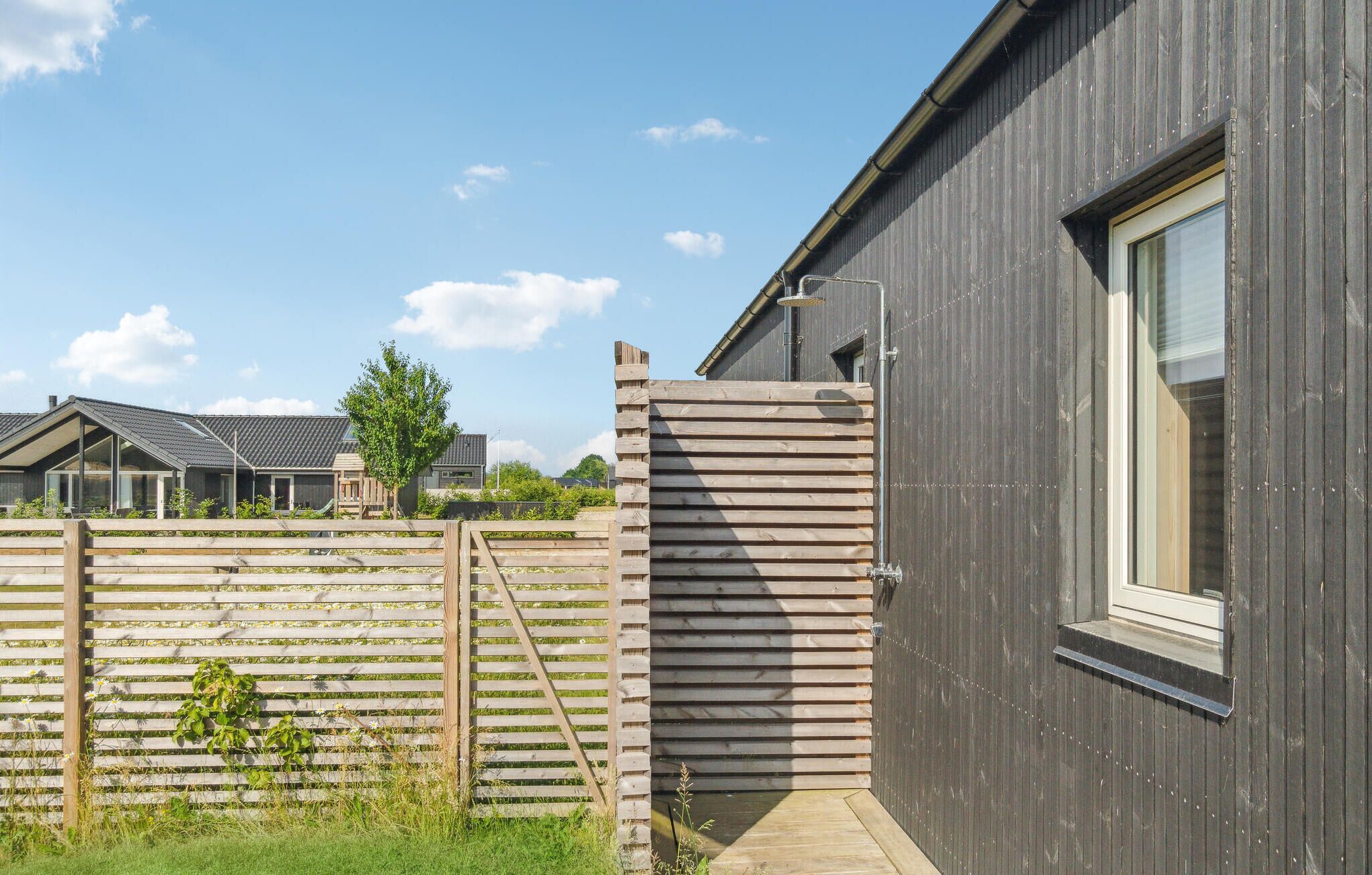 Un bâtiment moderne à l’extérieur sombre, doté d’un portail en bois et surplombant un ciel dégagé.