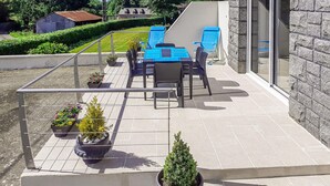 Una terraza con asientos al aire libre y plantas en macetas.
