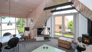 Una sala de estar moderna con televisor, asientos y chimenea.