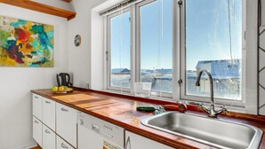 Eine moderne Küche mit großem Fenster, Geschirrspüler und einer Holz Arbeitsplatte.