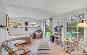 Relax in this inviting room with a comfortable bed, a reading nook, and a view of the garden.