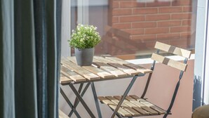 A balcony with a wooden table and a potted plant. - Modern, Stylish Apartment with balcony (Valencia)