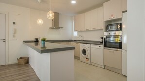 A modern kitchen with a central island, built-in appliances, and pendant lighting. - Modern, Stylish Apartment with balcony (Valencia)