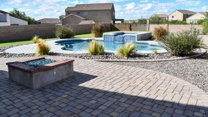 Et boligområde med swimmingpool, bålsted og en velplejet have.