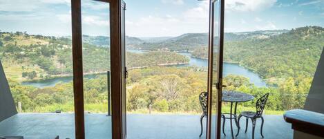 A balcony with a view of a lake and hills.