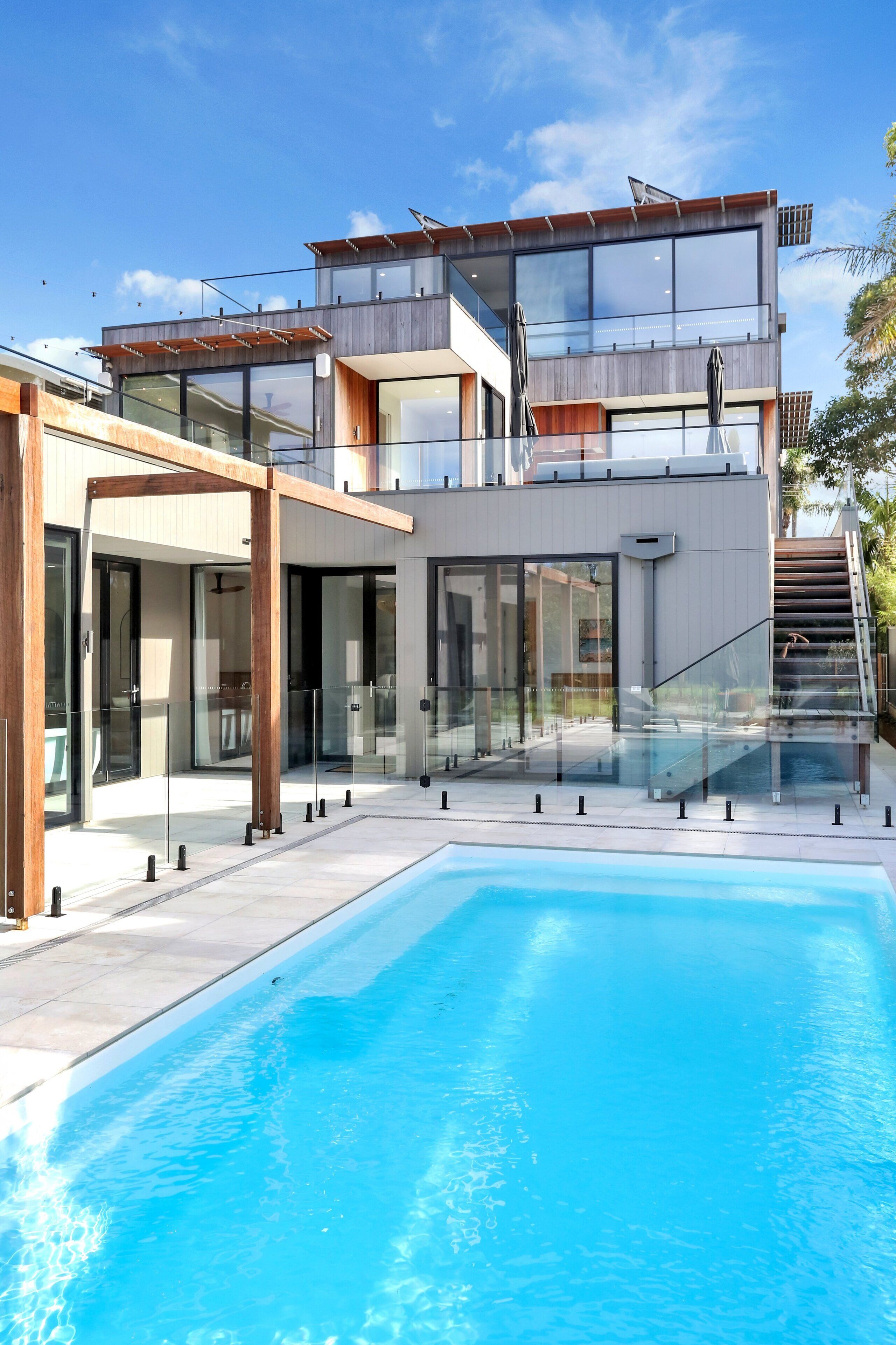 A modern two-story building with a swimming pool in the foreground.