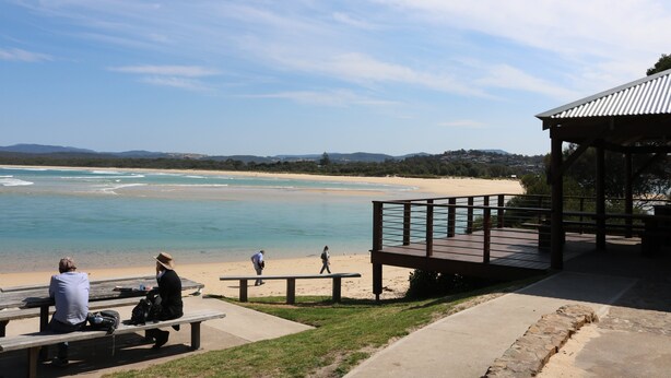 A beachside pavilion with a wooden deck and benches overlooking the ocean. - Beach Break: Pet friendly fenced yard in town (Merimbula)