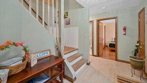 A staircase with a 'WELCOME' sign, a wooden bench, a wicker basket, and a potted plant. - Poconos Peaceful Retreat. Short drive to Ski, Swim, Hike, or Shop! 4 Bedrooms. (Tobyhanna)