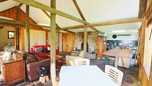 Een rustiek interieur met een houten eettafel, een bank en een keukenhoek.