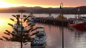 A harbor with boats docked at a pier during sunset. - Jodi's Beach Retreat: 2 bedroom pet friendly apartment (Eden)