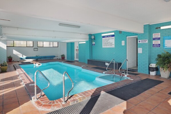 An indoor swimming pool with clear pool rules and a shower area. - Aquarius Merimbula 2x bedroom Superior unit (Merimbula)