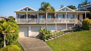 A two-story house with a balcony, a garage, and a staircase leading to the entrance. - Pelican Lake House - 4 bedroom pet friendly (Merimbula)