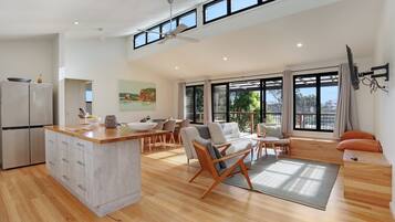 A modern open-plan living space with a kitchen, dining area, and seating area.