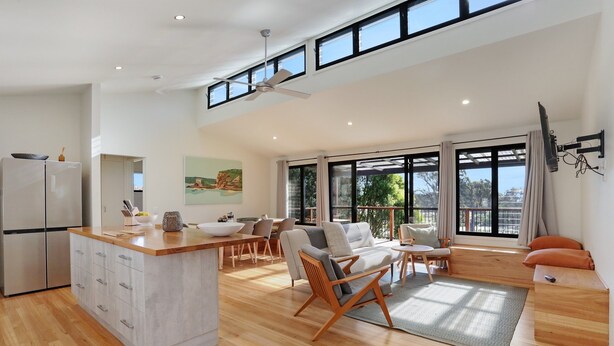 A modern open-plan living space with a kitchen, dining area, and seating area.