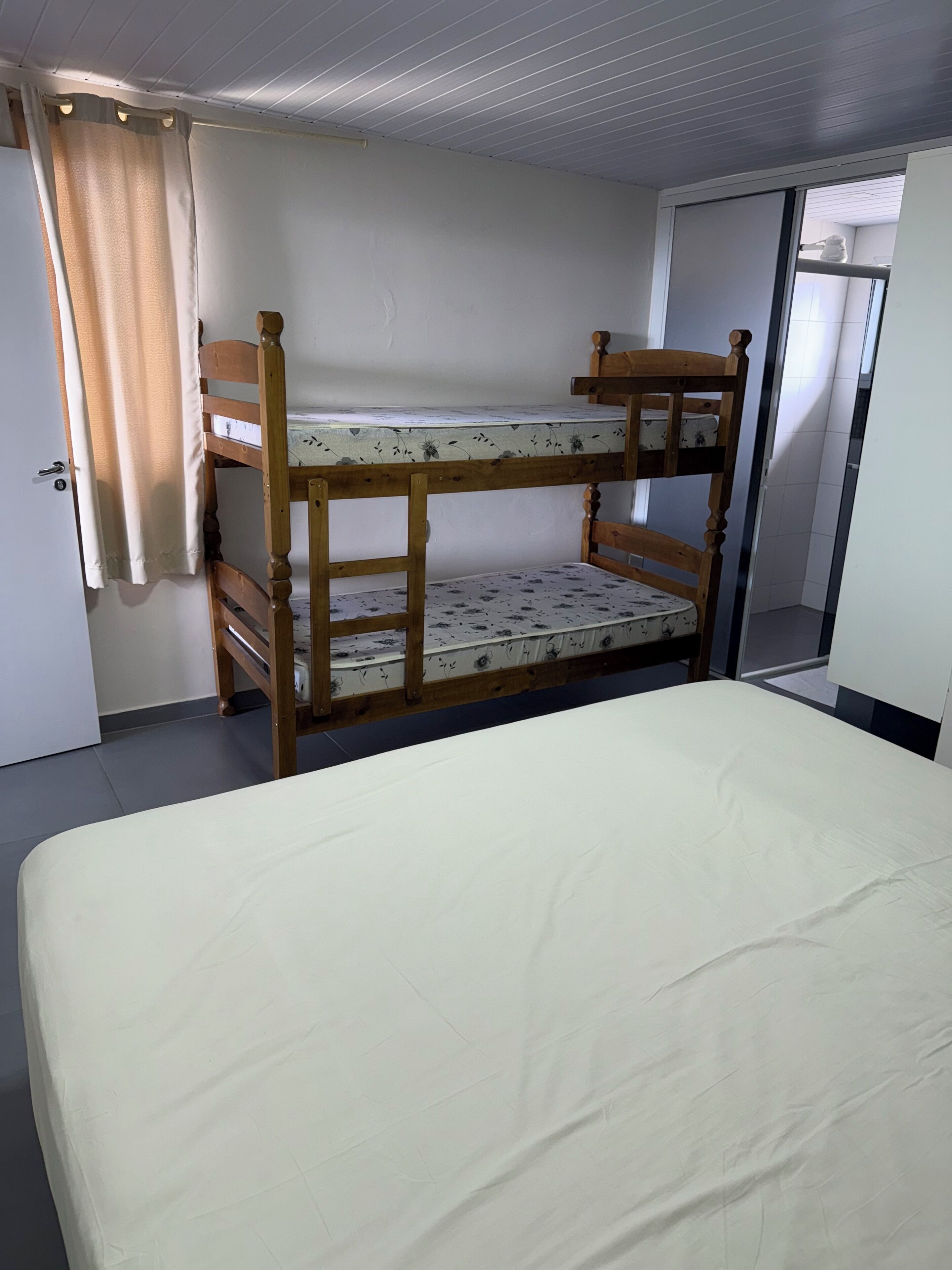Uma cama de solteiro com colchão e uma cama inferior com travesseiro.
