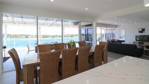 Un salon moderne doté d’une grande porte vitrée donnant sur un balcon avec vue sur une étendue d’eau.