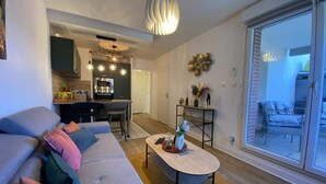 Un salon moderne avec un canapé, une table basse et un coin repas à l’arrière-plan.