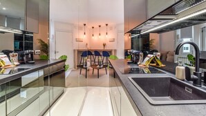 Una cocina moderna con una isla central, un comedor con sillas y un ventanal grande.
