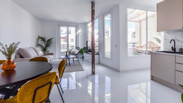 Un appartement moderne comprenant un coin repas, une cuisine et un espace de vie.