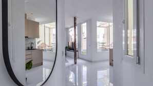 Une cuisine moderne dotée d’un plan de travail en marbre et offrant une vue sur l’espace extérieur grâce à de grandes fenêtres.