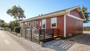 Ein rotes Holzgebäude mit der Nummer 22 an der Seite, einem verschlossenen Eingang und einer Schotterauffahrt.