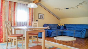 Un soggiorno accogliente con un divano blu, un tavolo da pranzo in legno e sedie.
